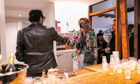 a man is standing in front of a bar with drinks