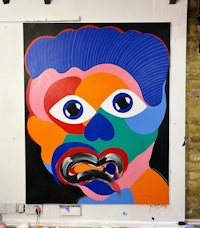 a painting of a colorful face in a studio